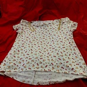 Off the shoulder floral blouse with shoulder chain adornment.